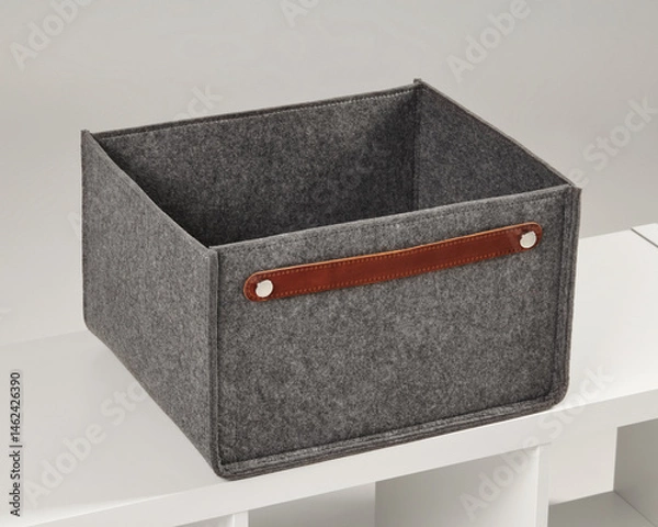 Fototapeta Empty grey felt storage box with leather handle sitting on white shelf