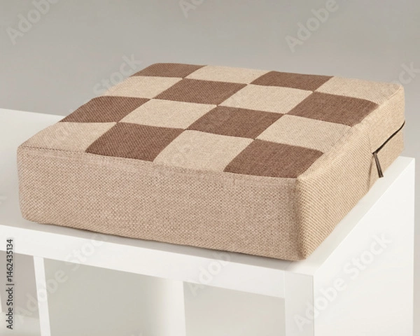 Fototapeta Checkered brown and beige seat cushion resting on white shelf