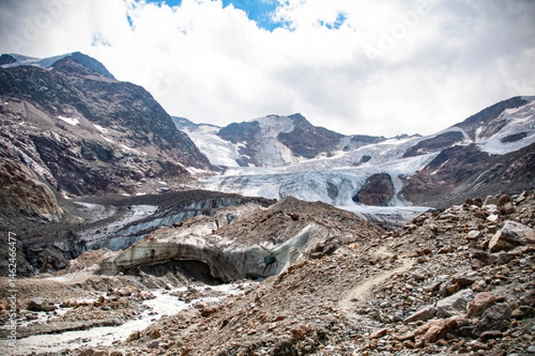 Fototapeta Snowy alpine peak with glacier and cloudy sky