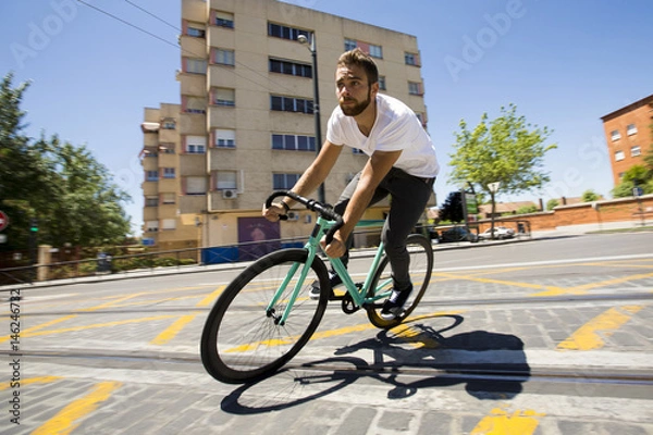 Obraz Cyclist man riding fixed gear sport bike in sunny day on a city