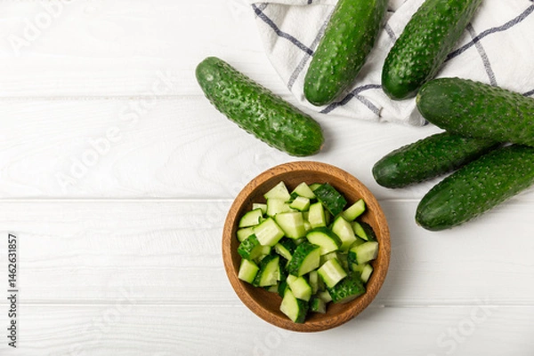 Obraz Cucumber on wooden background. Slice of cucumber on background. Fresh organic green cucumbers gherkin. Vegan. Salad ingredient. Farm vegetables. Cut vegetables with knife. Space for text. Copy space