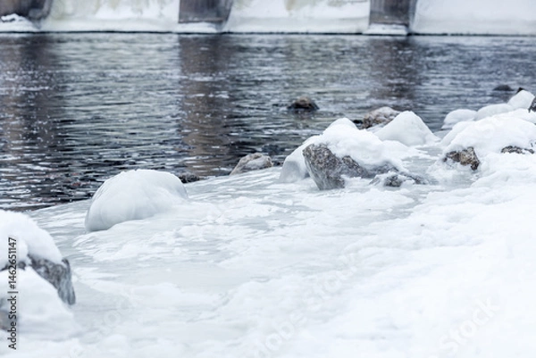 Fototapeta A frozen lake with a few rocks on it