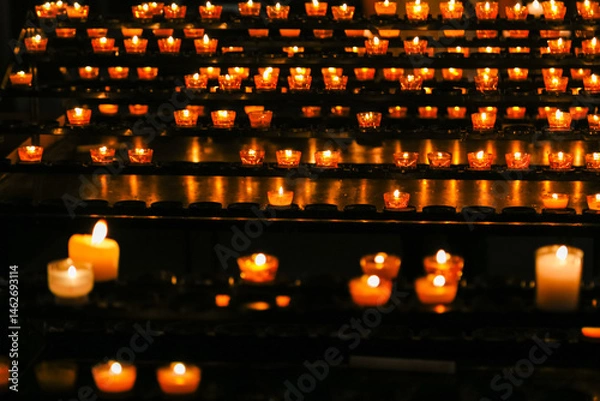 Obraz A row of candles are lit in a church