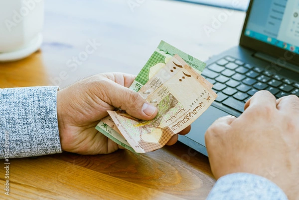 Fototapeta Close up of a man's hand counting money Omani money