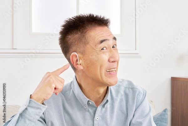 Obraz 補聴器を付けたシニア男性　リビング