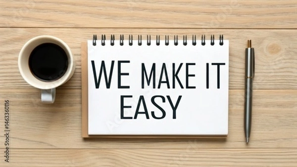 Fototapeta Modern wealth savings and financial growth. Notebook with the phrase "We make it easy," a coffee cup, and a pen on a wooden table.