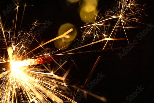 Obraz Happy New Year and Merry Christmas, Glittering burning sparkler against blurred bokeh light background