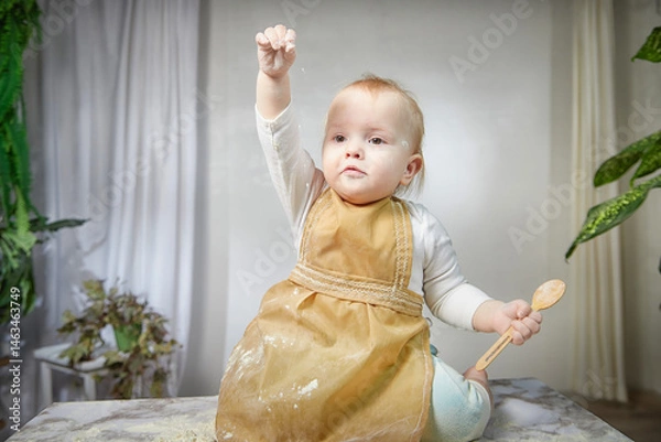Fototapeta A young girl joyfully plays with flour during a creative cooking-themed photo shoot in a studio setting