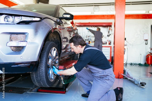 Fototapeta Auto mechanic repairing car. Selective focus. 