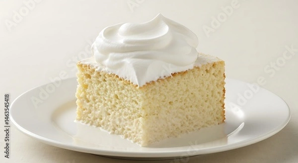 Fototapeta A slice of tres leches cake with whipped cream on a white plate