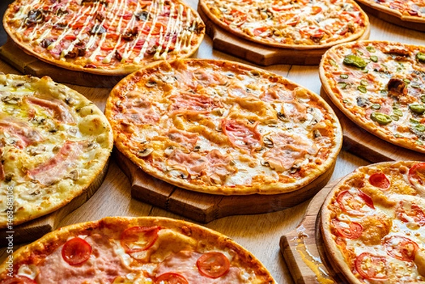 Obraz An inviting display of multiple pizzas with vibrant toppings, perfect for sharing among friends