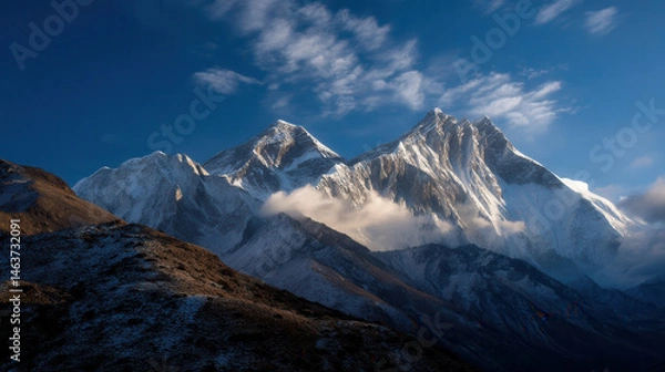 Obraz Mount everest snow peak ridge cloud dawn light illuminate jagged summits, creating breathtaking alpine panorama at sunrise with misty valleys and deep blue sky framing monumental peaks