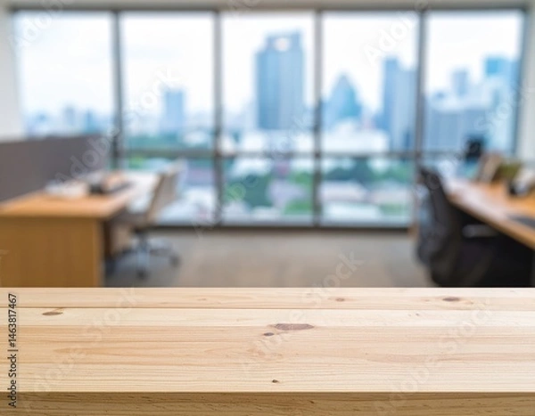 Fototapeta Modern office space with a wooden table in focus, showcasing a blurred cityscape through large windows, suggesting a professional environment