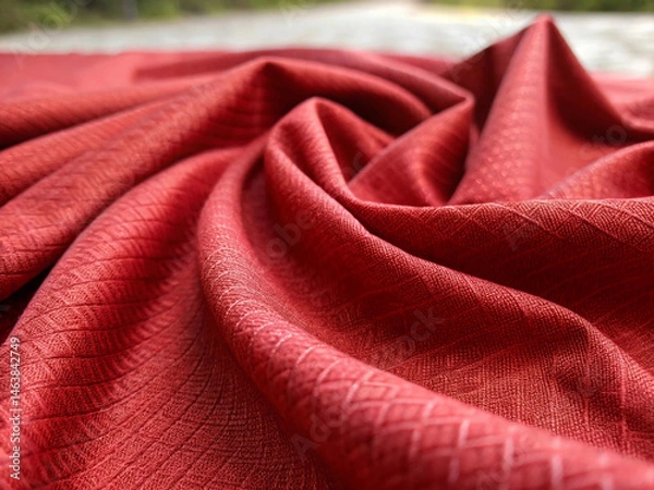 Fototapeta With a blurred background emphasizing the material, folded red fabric displays a subtle geometric weave and a range of tonal depths due to lighting
