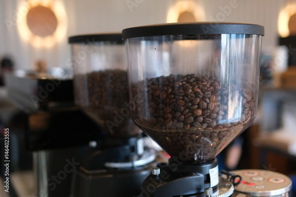 Obraz Coffee beans are placed next to a manual grinder. High quality photo