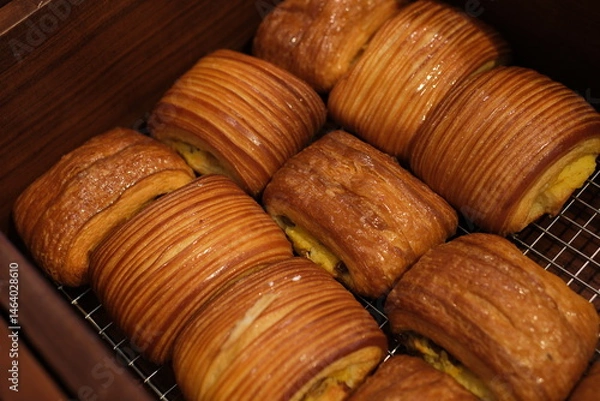 Obraz Golden layered pastry on plate in natural light With puffed edges and a delicate sugar coating, these pastries evoke a rustic charm perfect for breakfast or dessert. High quality photo