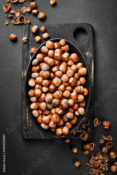 Obraz Nuts background. Hazelnuts in a black oval bowl. Healthy Eating. Close up.