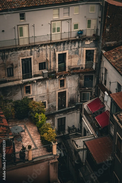 Obraz Old residential buildings with rustic balconies, air conditioners, and rooftop terraces in Catania, Sicily, Italy. Moody urban atmosphere with Mediterranean charm.