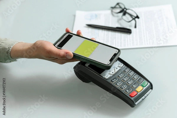 Fototapeta Hands using pos terminal  and smart phone to complete nfc payment, financinal operation.