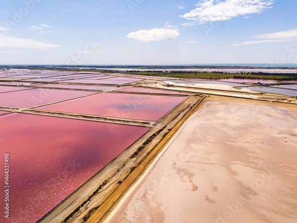 Fototapeta Aigues-Mortes, Camargue, France,  the largest mediterranean salt marshes in beautiful pink and red colors, for production of table salt, and a mount of white salt  