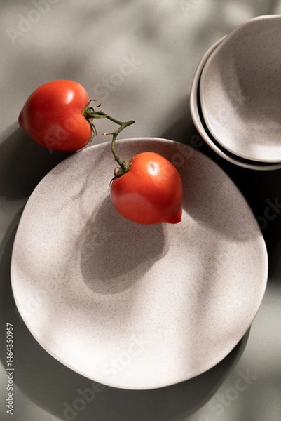 Fototapeta Flat lay of gray monochrome plates and tomatoes. Culinary concept with space for text
