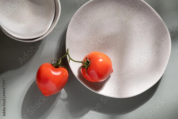 Fototapeta Flat lay of gray monochrome plates and tomatoes. Culinary concept with space for text
