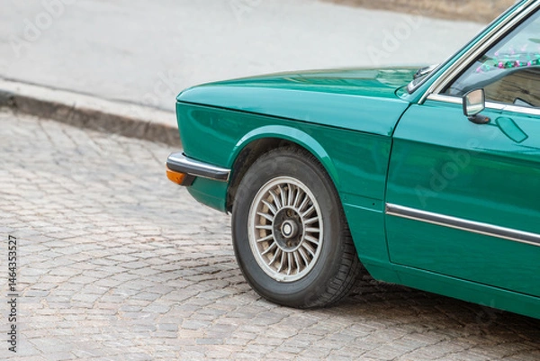 Fototapeta Retro car on a background of cobblestones. Front of the car. Side view.