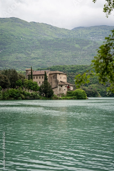 Fototapeta Scenic View Of Lake Toblino, Italy, Framed By Trees With A Historic Castle On The Shore
