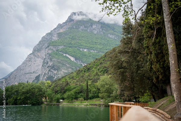 Fototapeta Stunning View Of Lake Toblino In Italy, Framed By Trees With A Majestic Mountain In The Background
