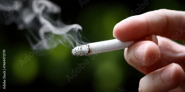 Fototapeta Close-up photo of a hand extinguishing a cigarette, with smoke in the background
