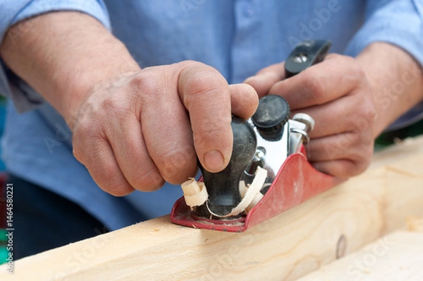 Fototapeta leveling wood with a plane, close-up of carpenter's hands