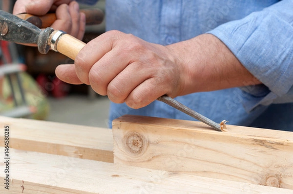 Fototapeta carpenter is working with a chisel closeup