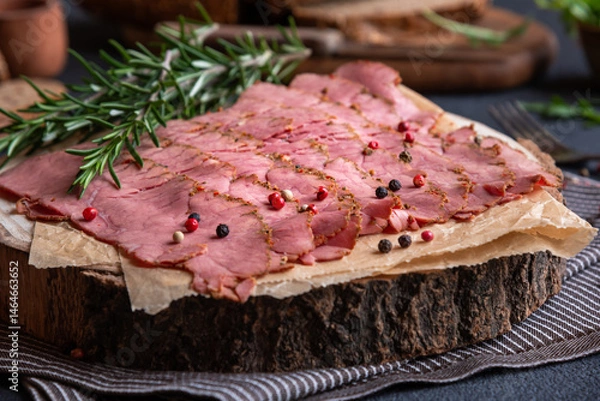 Obraz Sliced pastrami meat with rosemary and pepper