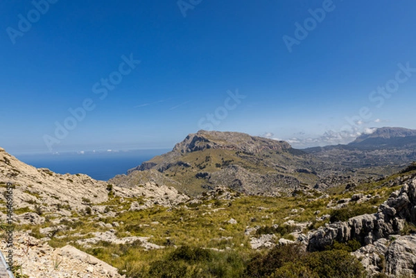 Fototapeta The Spanish island of Mallorca - beautiful views of green mountains, cliffs, the Mediterranean Sea and blue skies