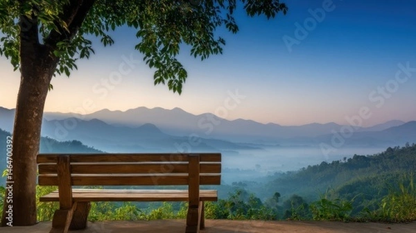 Fototapeta Serene Morning View from a Wooden Bench Overlooking Misty Mountains and Lush Green Valleys