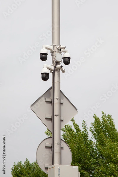 Fototapeta Surveillance cameras mounted on a pole against the sky
