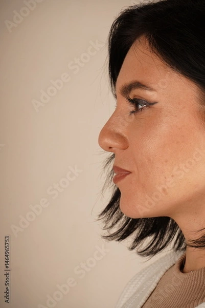 Obraz The ear of a woman is captured up close, with loose, dark hair softly cascading around it. The image highlights subtle beauty and natural elegance. A serene and detailed portrayal.