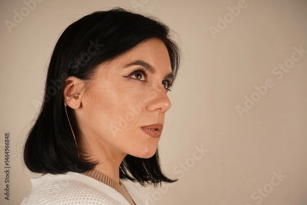 Obraz Beautiful image of a woman of European appearance. Calm close-up of a woman standing in a relaxed pose, radiating natural charm. Side view of a young woman.
