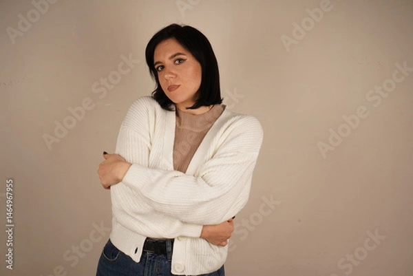 Obraz A woman arms crossed on her breast, symbolizing confidence and perseverance. Her posture conveys unwavering commitment. The woman stands confidently and smiling.