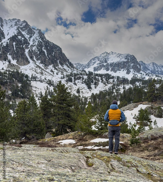 Fototapeta Hiker contemplating snowy mountain peaks in the pyrenees during spring.