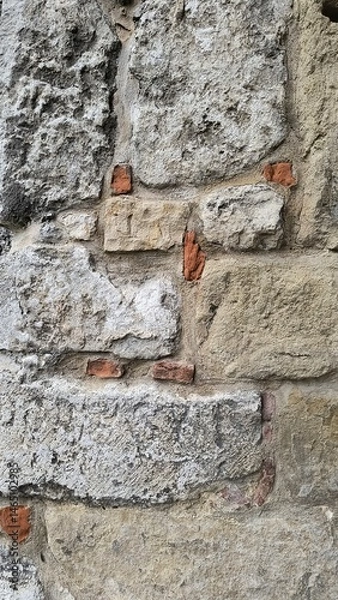 Obraz Textured stone wall showcasing brick accents in an old building during daylight hours