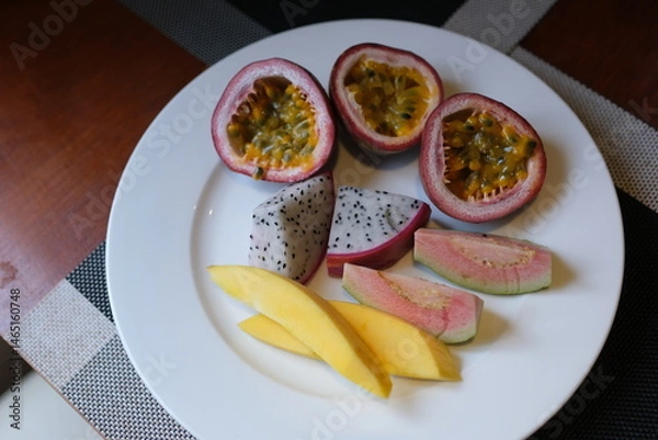 Obraz white plate Two pieces of mango guava dragonfruit and passion fruit. High quality photo