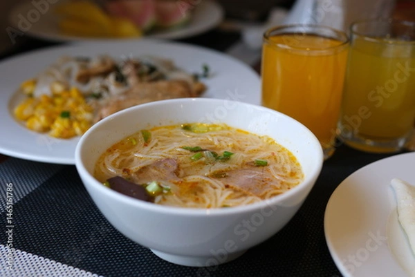 Obraz asian style rice soup with herbs in a bowl , fresh salad and milk , orange juice. High quality photo