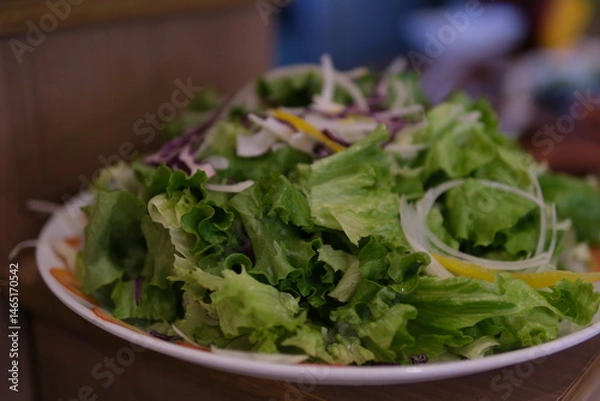 Obraz Fresh green salad in plate made of green leaves mix. Variety of healthy fresh harvested eatable greens. Raw food , organic, detox diet concept. White background, copy space, top view flat lay.