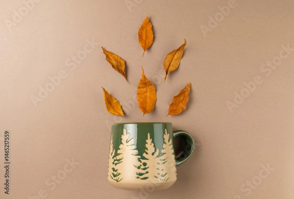 Obraz Mug with autumn leaves on beige background. Flat lay, top view.