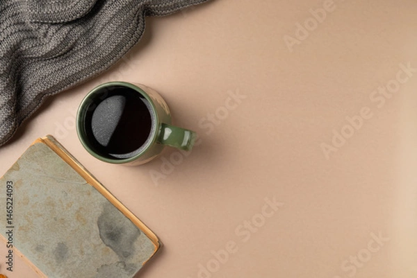 Obraz Cup of tea with book and pullover on beige background. Flat lay, top view.