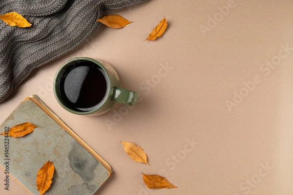 Obraz Cup of tea with book and leaves on beige background. Flat lay, top view.