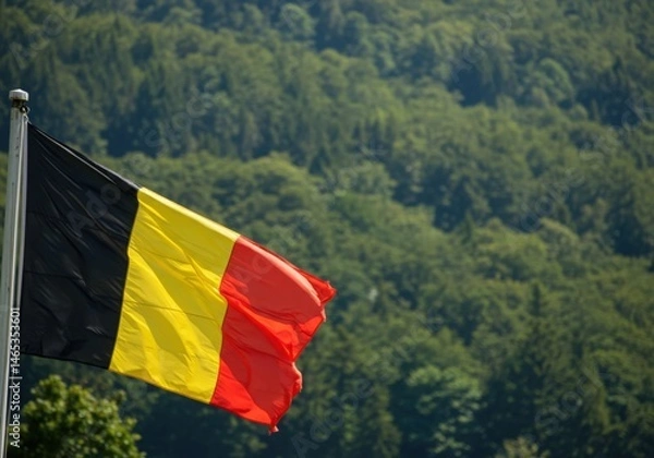 Fototapeta Waving Belgian Flag Representing National Unity Amidst the Dense Rolling Forests of the Ardennes