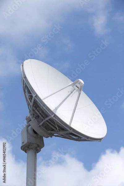 Fototapeta Satellite dish stands tilted upwards against a blue sky, capturing signals. Communication technology, signal reception, sky observation