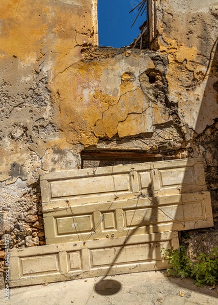 Fototapeta old door panels blokking the entrance of an abandoned house in Gythio, Greece